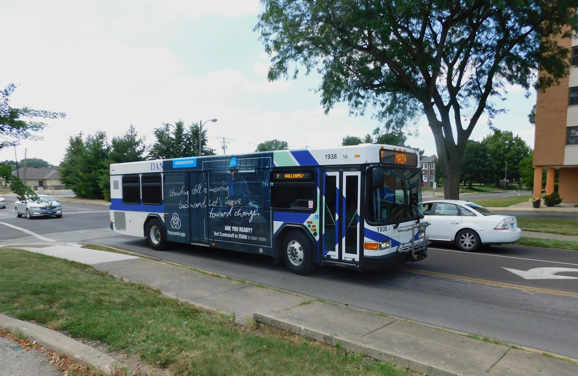 Bus with an advertisement on its side driving down a road